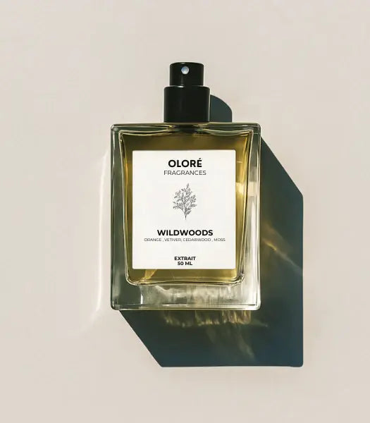 Olore Wildwoods perfume bottle with ingredients on a white background