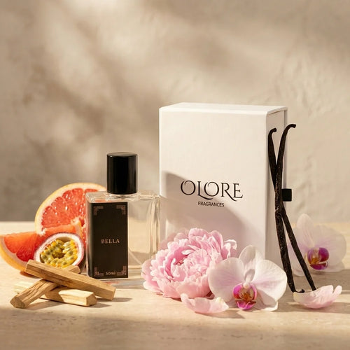 Oloren Bella perfume bottle with flowers and packaging on a wooden surface