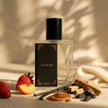 Perfume bottle labeled 'Samar' with strawberries, vanilla beans, and cinnamon on a neutral background