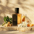 Perfume bottle labeled 'SARAH' with fruits and flowers on a wooden surface